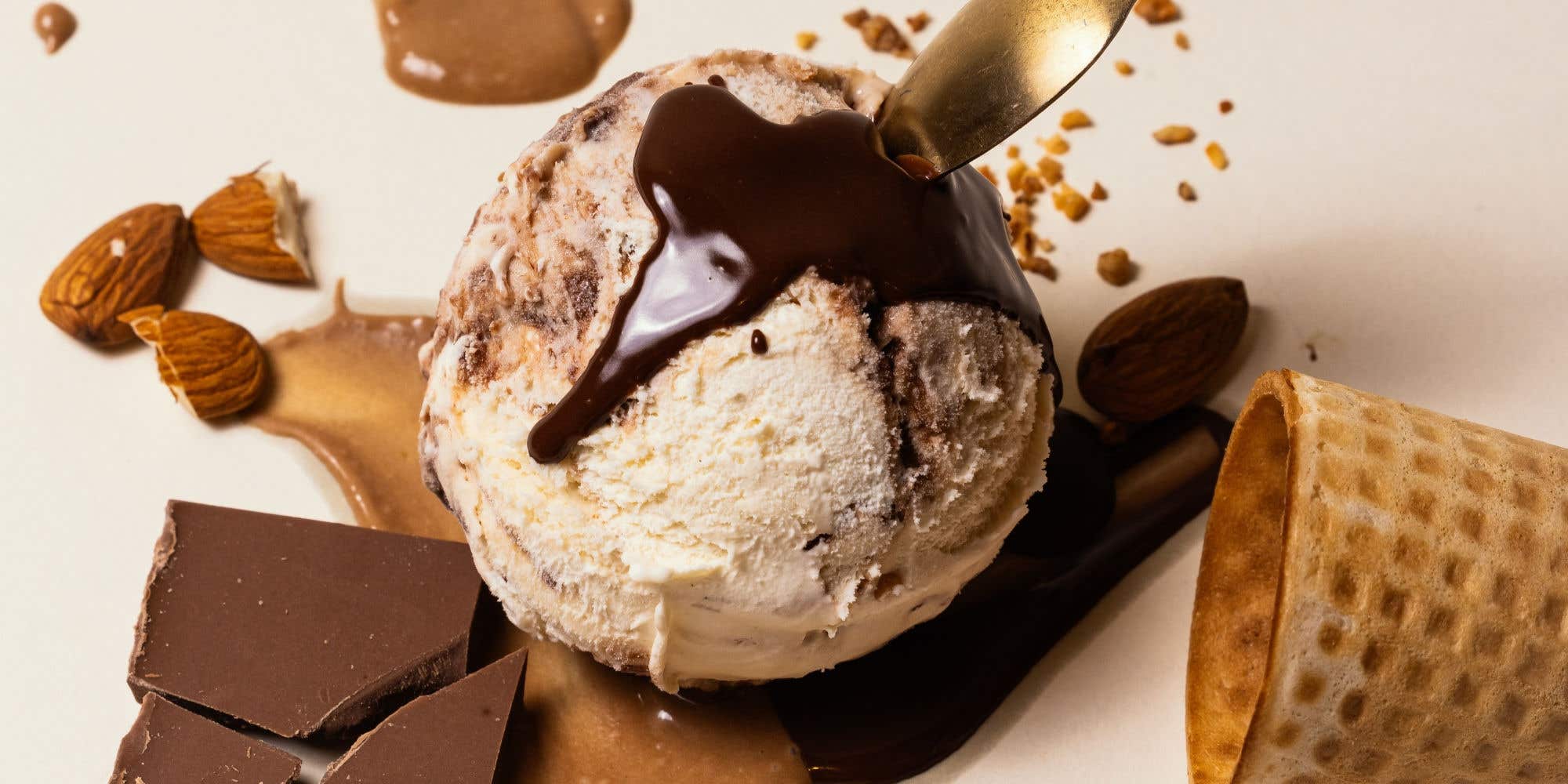 Gelato topped with chocolate sauce, almonds, and chocolate chunks
